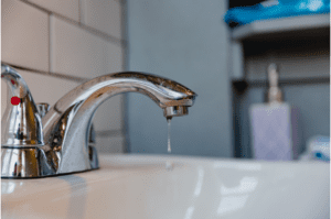 A tap with constant dripping water in the bathroom
